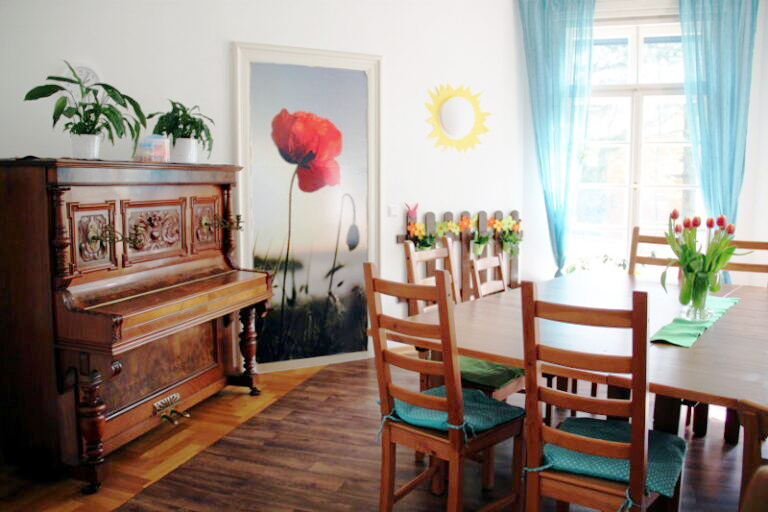 Freundlicher Wohnbereich mit Tisch, Stühlen und Klavier