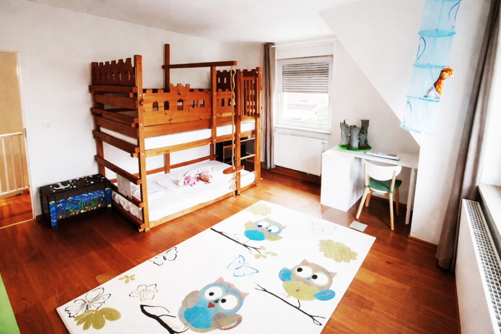 Freundlicher Wohnbereich mit Hochbett und Schreibtisch