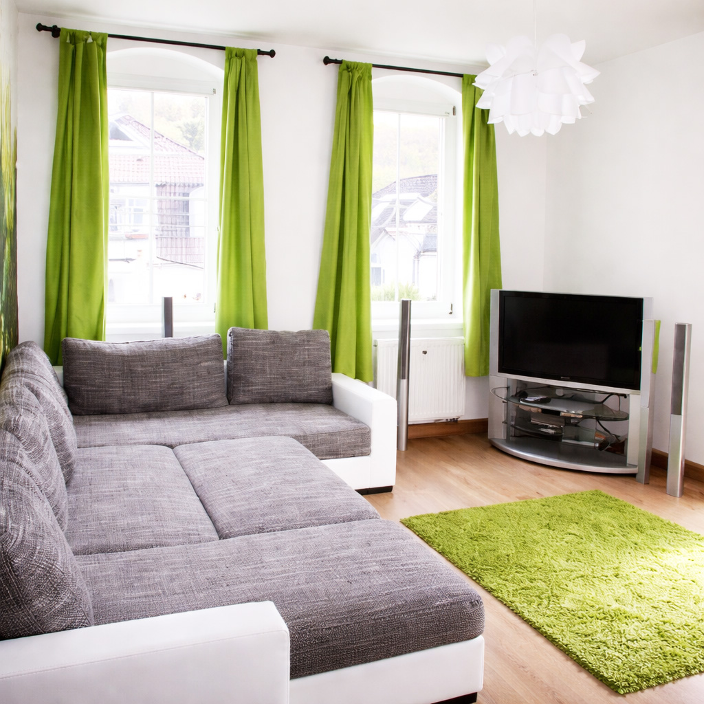 Freundlicher Wohnbereich mit Couch und TV Gerät