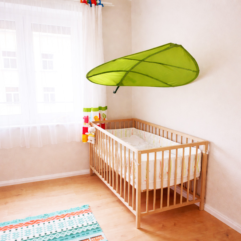 Freundlicher Wohnbereich mit Babybett