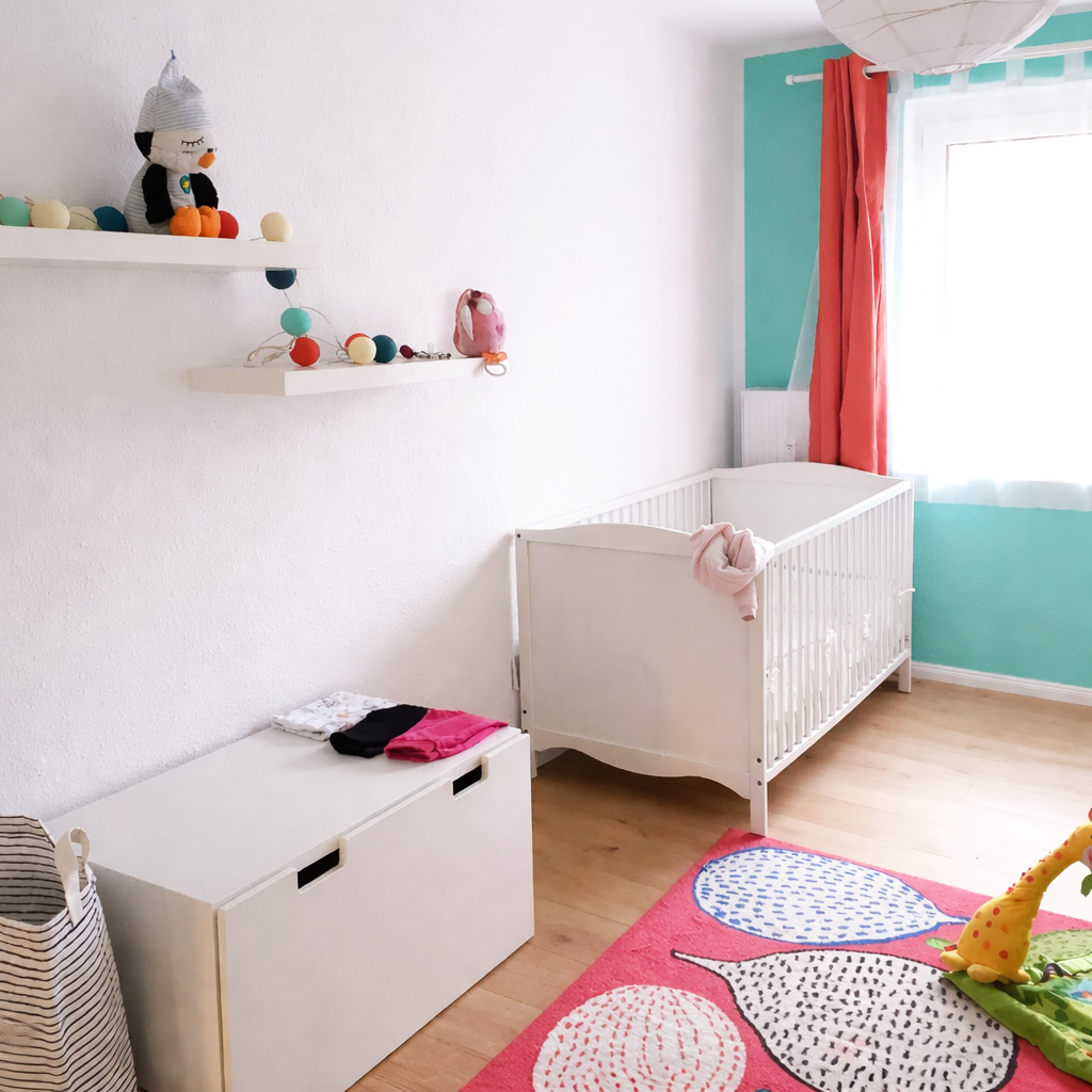 Freundlicher Wohnbereich mit Kinderbett und Möbeln